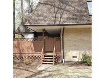 Inviting covered porch with wood lattice and brick exterior, creating a warm, welcoming entrance at 240 Brookberry Cir, Chapel Hill, NC 27517