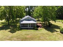 Scenic aerial view of a home with a screened porch, wooden deck, and spacious lawn at 3997 Swanns Station Rd, Sanford, NC 27332