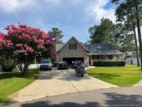 Charming single-Gathering home features well-kept lawn, mature landscaping, and inviting front porch at 49 Pebble Beach Pt, Sanford, NC 27332