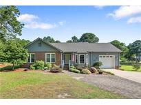 Charming single-story home featuring a brick and siding exterior, well-manicured lawn, and a paved driveway at 73 Night Heron Ct, Sanford, NC 27332
