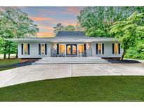 Charming home with inviting front porch featuring rocking chairs and a beautifully landscaped yard at 220 Topside, Sanford, NC 27332