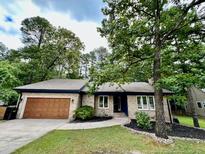 Charming single-story brick home featuring a well-manicured front yard and attached two-car garage at 75 Port Tack, Sanford, NC 27332