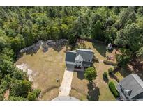 An aerial view shows a charming two-story home nestled in lush greenery with a private backyard at 140 Chinkapin Oak Cir, Bunnlevel, NC 28323