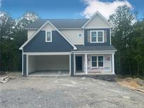 Two-story home with blue and white siding, attached two-car garage, and covered front porch at 171 Travelers Way, Lillington, NC 27546