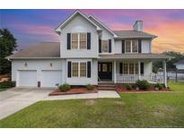 Charming two-story home featuring a welcoming front porch and a well-maintained lawn, perfect for curb appeal at 186 Yorkshire Dr, Cameron, NC 28326