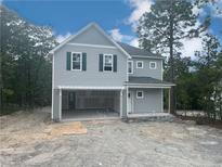 Charming two-story home featuring gray siding, green shutters, and an attached two car garage at 189 Travelers Way, Lillington, NC 27546