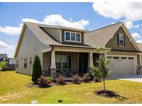 Charming home featuring a well-manicured lawn, inviting front porch, and attached garage at 70 Waxflower Dr, Smithfield, NC 27577