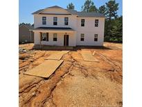 A bright two-story home featuring a white exterior, black roof, and a charming front porch at 214 Uwharrie Way, Sanford, NC 27330