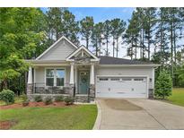 Charming single Gathering home showcasing a well-manicured lawn, quaint porch and an attached two car garage at 25 Glenside Ct, Spring Lake, NC 28390