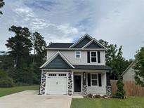 Charming two-story home with gray siding, black shutters, and a well-manicured lawn at 4161 Overhills Rd, Spring Lake, NC 28390