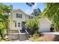 Charming two-story home with a deck, attached garage, and nicely landscaped front yard on a sunny day at 70 Oregon Ln, Spring Lake, NC 28390