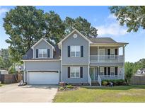 Charming two-story home with gray siding, white trim, an attached garage, and a well-manicured lawn at 717 Lenoir Dr, Spring Lake, NC 28390