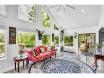 Sunroom showcasing a pink couch, area rug, and many windows overlooking lakefront scenery at 181 Tree Cutters, Sanford, NC 27332