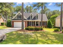 Charming brick home featuring a well-manicured lawn, attached garage and mature trees at 60 Rolling Pines Dr, Spring Lake, NC 28390
