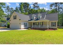 Charming single-Gathering home with a manicured lawn, covered porch, and an attached two car garage at 99 Riviera Ln, Sanford, NC 27332