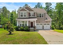 Charming two-story home with a well-manicured lawn and an attached two-car garage at 252 School Side Dr, Spring Lake, NC 28390