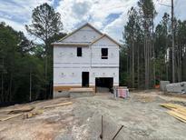 Image shows the unfinished, framed exterior of the two-story home with materials and framing exposed at 29 Horse Trot Ln, Sanford, NC 27332