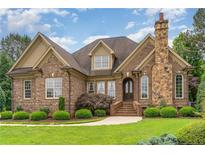 Charming brick home with stone chimney, manicured lawn, and beautiful landscaping at 4012 Sorrell Brothers Ct, Raleigh, NC