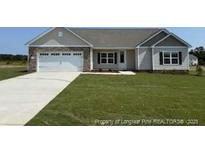 Charming single-story home featuring a well-manicured lawn and attached two-car garage at 107 Camp Rock Rd, Lillington, NC 27546