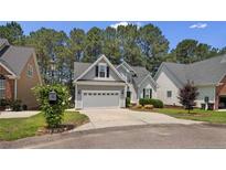 Charming home featuring a two-car garage, manicured lawn, and mature trees at 15 London Way, Spring Lake, NC 28390
