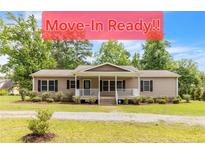 Charming ranch-style home featuring a welcoming front porch and well-maintained landscaping at 2003 Spring Ln, Sanford, NC 27330