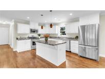Bright kitchen featuring white cabinets, stainless steel appliances and hardwood floors at 2003 Spring Ln, Sanford, NC 27330