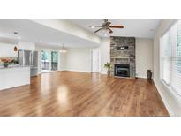 Bright living room features wood floors, stone fireplace and sliding doors to a wood deck at 2003 Spring Ln, Sanford, NC 27330