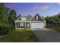 Charming home with a lush front lawn, covered porch, and two-car garage at 40 Savanah Ct, Sanford, NC 27332