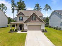 Charming two-story home with a well-manicured lawn, a covered porch, and an attached two-car garage at 453 Falls Creek Dr Dr, Spring Lake, NC 28390