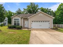 Charming single-story home featuring a two-car garage, manicured lawn, and classic design elements at 841 Golden Horseshoe Ln, Sanford, NC 27330
