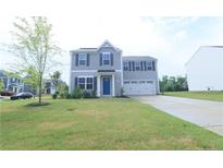 Charming two-story home with blue door, two-car garage, and manicured lawn at 96 Cutty Way, Lillington, NC 27546
