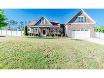 Beautiful two-story home featuring stone accents, a two-car garage, and a well-manicured lawn at 30 Regal Pond Dr, Angier, NC 27501