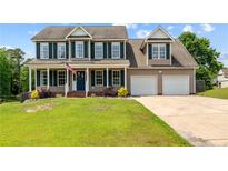 Charming two-story home featuring a covered front porch, well-manicured lawn, and a two-car garage at 383 Yorkshire Dr, Cameron, NC 28326