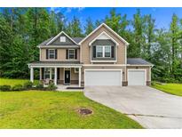 Inviting two-story home with a covered porch, attached two-car garage, and well-maintained front lawn at 446 Birch Ave, Spring Lake, NC 28390