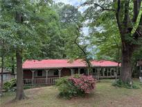 Charming single-story home with a red roof, covered porch and mature landscaping at 467 Deep River Rd, Sanford, NC 27330
