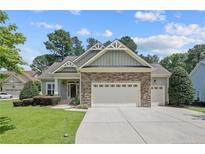 Charming home featuring a stone facade, well-manicured lawn, and a two-car garage at 71 Orchard Falls Dr, Spring Lake, NC 28390