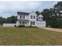Charming two-story home with a well-manicured lawn and a classic white facade at 19 Ribbon Oak Ct, Sanford, NC 27332