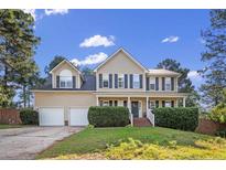Charming two-story home with a well-manicured lawn, dormers and a classic columned front porch at 40 Union Cir, Lillington, NC 27546