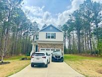 Inviting two-story home with a mix of stone and siding, complemented by a well-maintained front yard and driveway at 50 Teal Dr, Youngsville, NC 27596