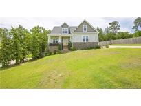 Charming two-story home featuring stone accents, a yellow front door, and a spacious front yard at 576 Executive Dr, Lillington, NC 27546