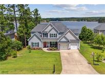 Inviting two-story home with a well-manicured lawn and lake view at 87 Pelican Ct, Sanford, NC 27332