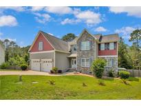 Charming two-story home with a stone facade, three-car garage, and well-manicured lawn at 175 Revere Way, Cameron, NC 28326