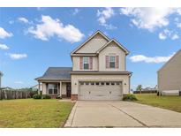Charming two-story home featuring a two-car garage and well-maintained front lawn at 110 Summerseat Way, Bunnlevel, NC 28323
