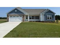 Charming single-story home with a manicured lawn and a two-car garage, offering modern curb appeal at 127 Camp Rock Rd, Lillington, NC 27546