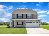 Charming two-story home with stone accents and a well-manicured lawn at 136 Camp Rock Rd, Lillington, NC 27546