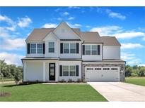 Charming two-story home featuring a stone-accented facade, black shutters, and a well-manicured lawn at 158 Camp Rock Rd, Lillington, NC 27546
