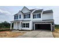 Two-story home with white siding, stone accents, large windows, and an attached two-car garage at 158 Camp Rock Rd, Lillington, NC 27546