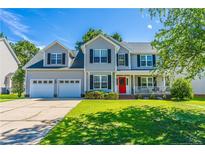 Charming two-story home featuring a two-car garage, well-manicured lawn, and a welcoming red front door at 191 Trenton Pl, Cameron, NC 28326