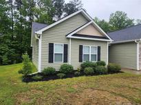 Charming single-story home with well-manicured landscaping and traditional architectural details at 207 Southwick Ct, Sanford, NC 27332