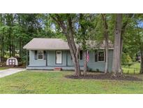 Charming one-story home with a covered front porch, an American flag, and mature trees in a quiet neighborhood at 2308 Keith Dr, Raleigh, NC 27610